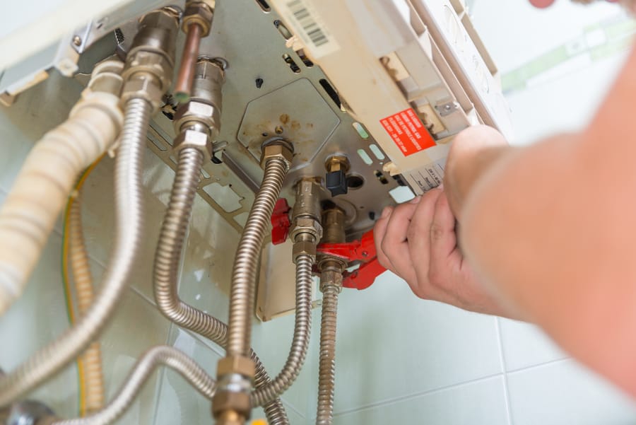 Flexible gas and water connectors at a wall-mounted heater